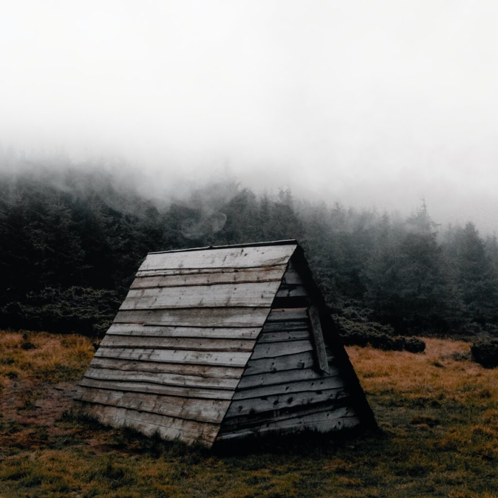 a wooden structure in the middle of a field