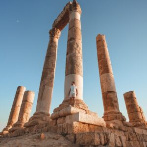 a man sitting on top of a stone structure