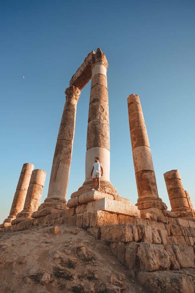 a man sitting on top of a stone structure